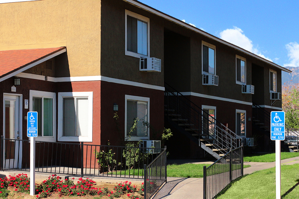 This image shows the exterior of the Villa De La Rosa Apartments
